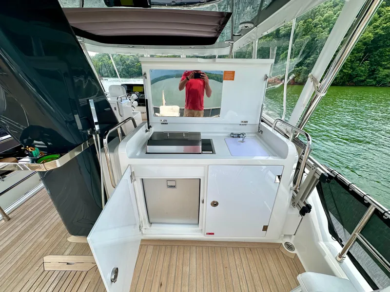 Slide: The Image of Outdoor kitchenette on 2021 Sirena 58 yacht with sink, grill, and storage, overlooking water. - 41