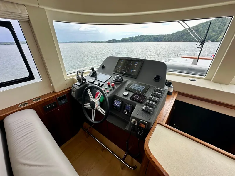 Slide: The Image of Helm of 2021 Sirena 58 yacht with modern controls and scenic water view. - 48