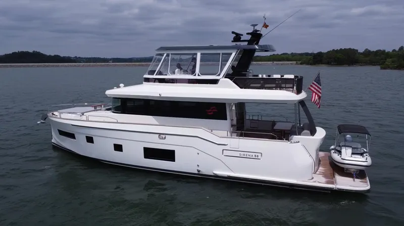 Slide: The Image of 2021 Sirena 58 yacht on water, featuring sleek design and American flag. - 5