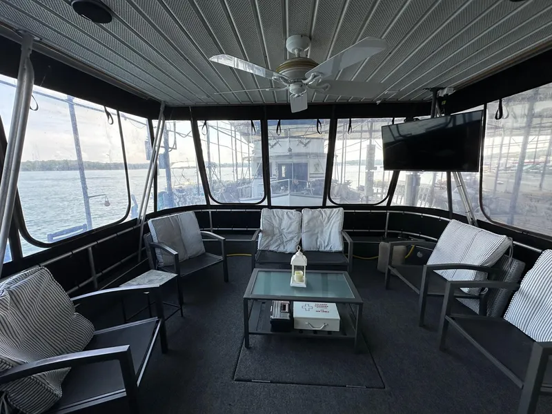 Slide: The Image of Enclosed deck of 1992 Sumerset 14x70 houseboat with seating, table, and TV. - 1