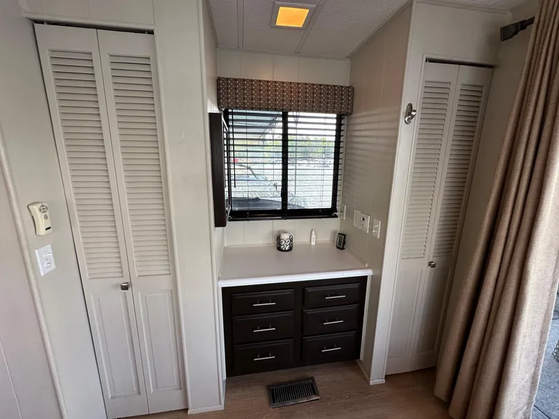 Slide: The Image of Interior of a 1992 Sumerset 14x70 houseboat with a vanity and storage cabinets. - 10