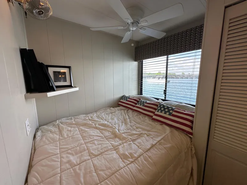 Slide: The Image of Cozy bedroom in 1992 Sumerset 14x70 houseboat with lake view and American flag pillows. - 6