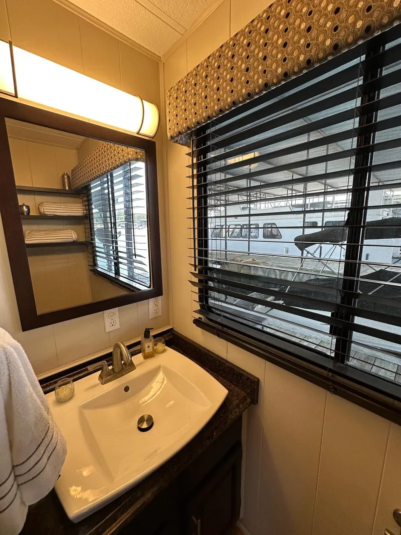 Slide: The Image of Bathroom interior of a 1992 Sumerset 14x70 houseboat with a window view of a marina. - 8