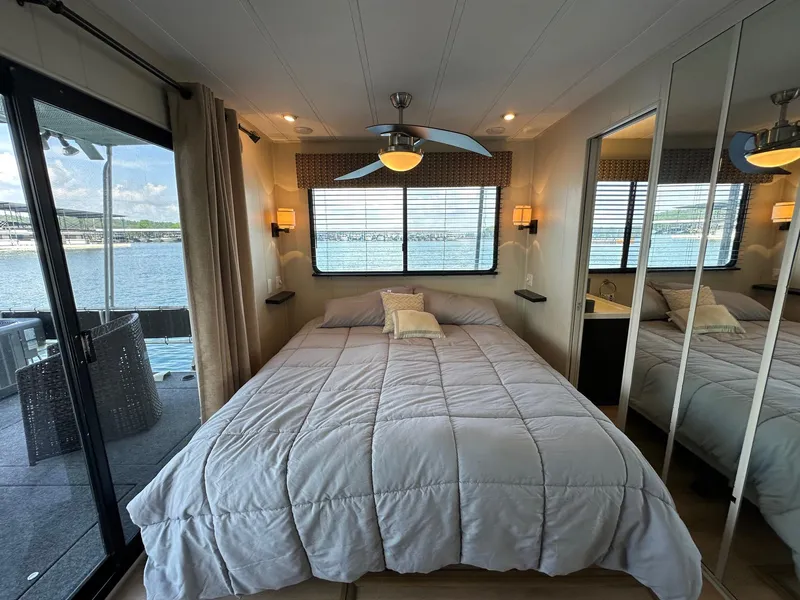 Slide: The Image of Bedroom interior of 1992 Sumerset 14x70 houseboat with lake view and modern decor. - 9