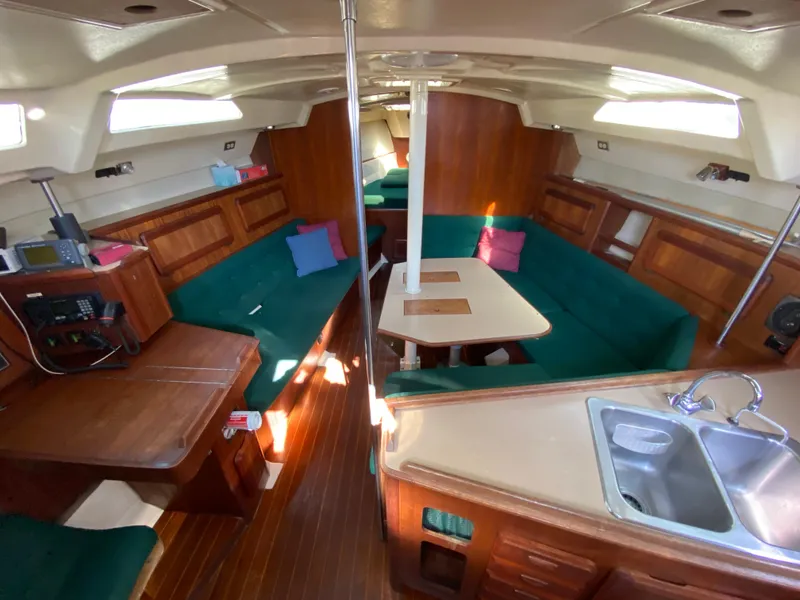 Slide: The Image of Interior of 1989 Hunter Legend 40 sailboat with green seating and wooden accents. - 12