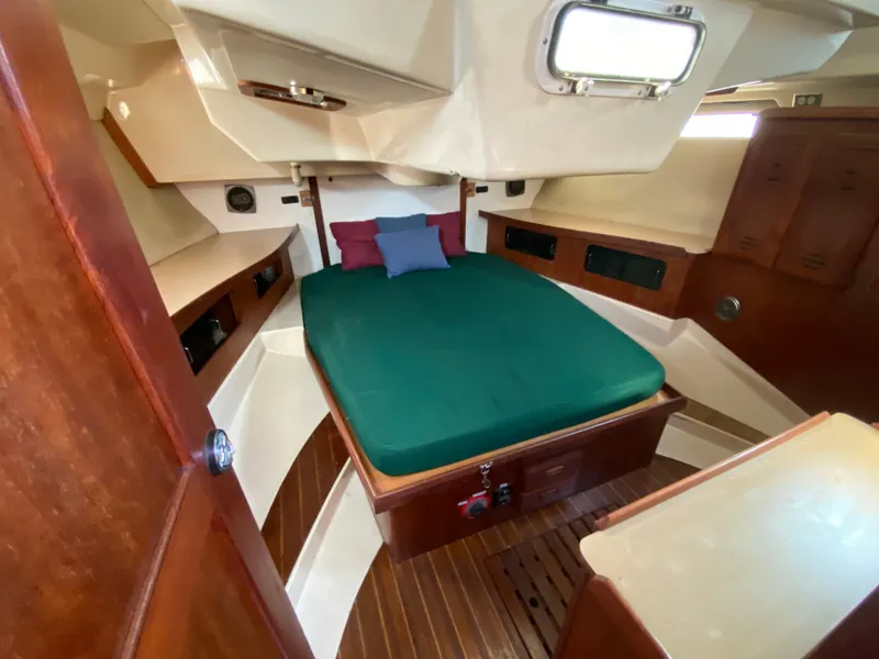 Slide: The Image of 1989 Hunter Legend 40 yacht cabin with green bedding and wooden interior. - 15