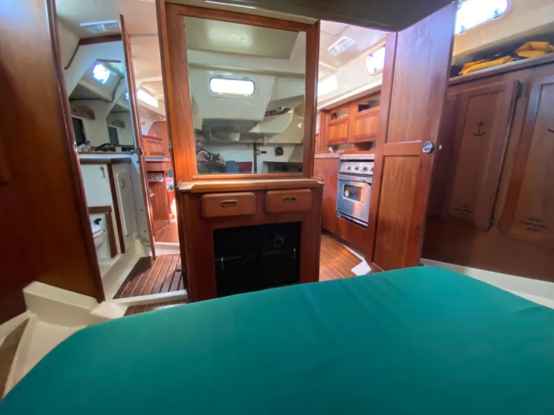 Slide: The Image of Interior of 1989 Hunter Legend 40 sailboat with wood cabinetry and teal bedding. - 18