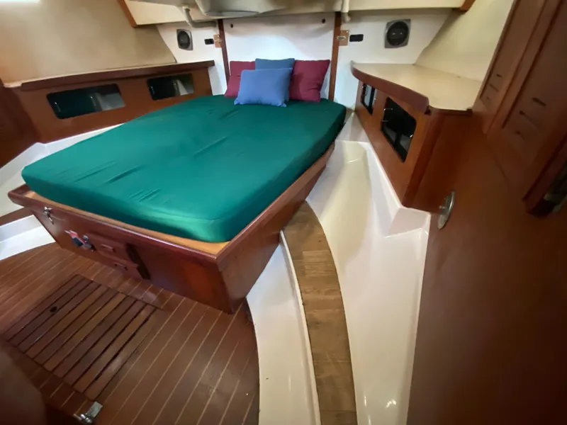Slide: The Image of 1989 Hunter Legend 40 yacht interior with green bed and wooden accents. - 19