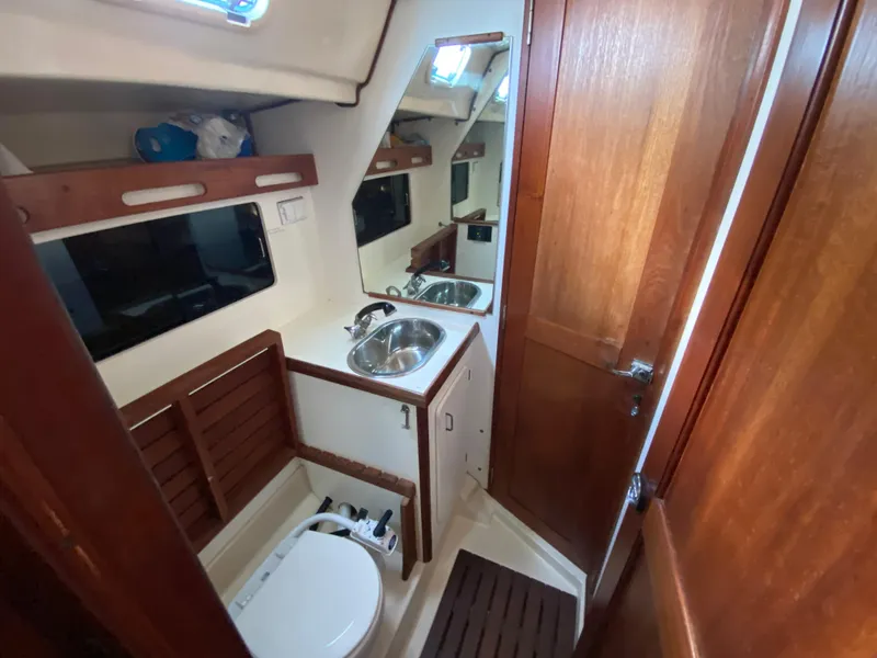 Slide: The Image of 1989 Hunter Legend 40 yacht bathroom with sink, toilet, and wooden cabinetry. - 20