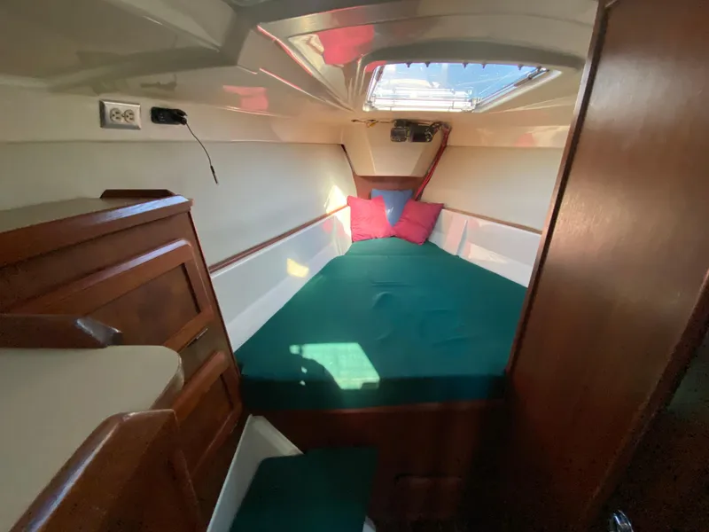 Slide: The Image of 1989 Hunter Legend 40 yacht cabin with green bedding and wooden interior. - 21