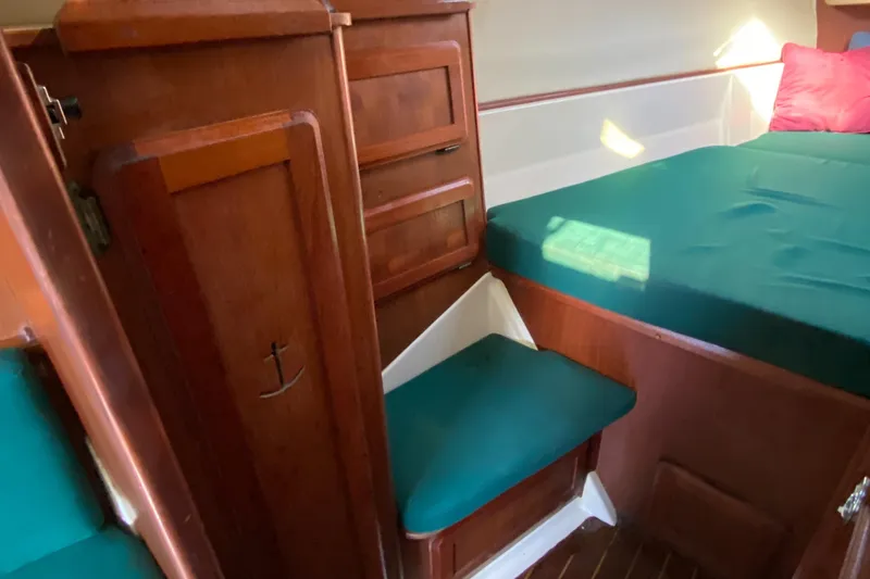 Slide: The Image of 1989 Hunter Legend 40 yacht interior with wooden cabinetry and green cushioned seating. - 22