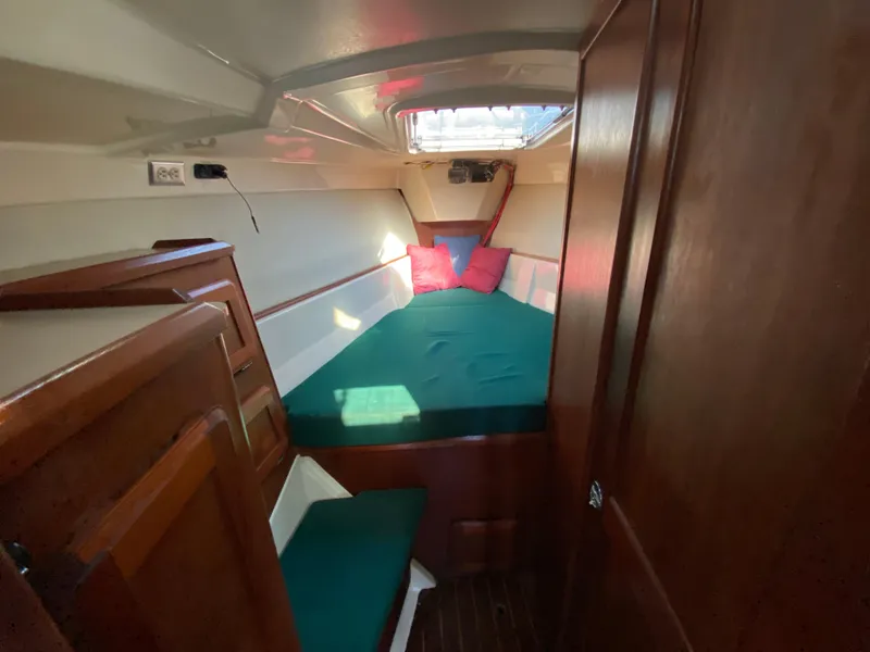 Slide: The Image of 1989 Hunter Legend 40 sailboat cabin with green bedding and wooden interior. - 23