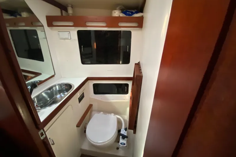 Slide: The Image of 1989 Hunter Legend 40 yacht bathroom with sink, toilet, and wooden accents. - 24
