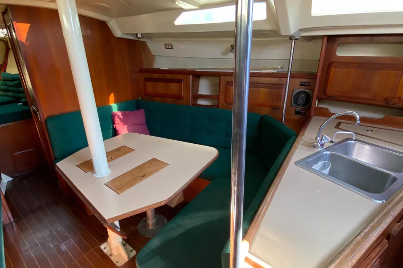 Slide: The Image of Interior of 1989 Hunter Legend 40 sailboat with green seating and wooden cabinetry. - 25