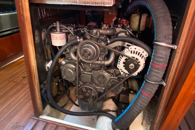 Slide: The Image of Engine compartment of a 1989 Hunter Legend 40 sailboat, showcasing mechanical components and hoses. - 31