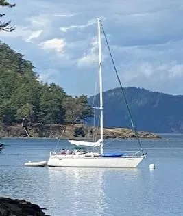 Slide: The Image of 1989 Hunter Legend 40 sailboat anchored in scenic coastal waters. - 32