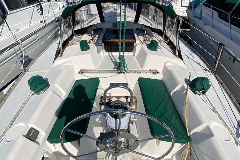 Slide: The Image of 1989 Hunter Legend 40 sailboat cockpit with green cushions and steering wheel. - 35