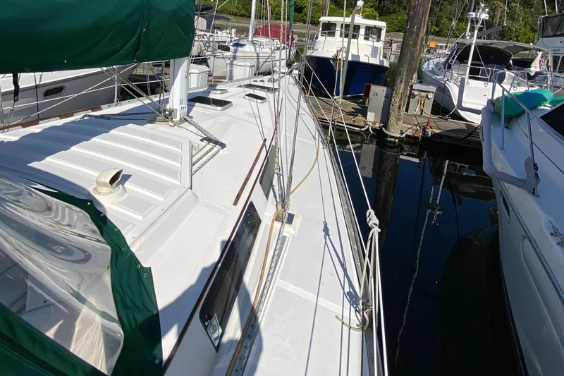 Slide: The Image of 1989 Hunter Legend 40 sailboat docked at marina, featuring green canopy and sleek white deck. - 36