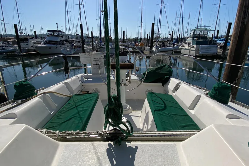 Slide: The Image of 1989 Hunter Legend 40 sailboat cockpit with green cushions, docked in a marina. - 39