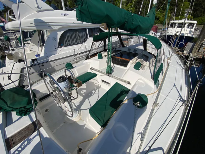 Slide: The Image of 1989 Hunter Legend 40 sailboat with green covers docked at marina. - 41