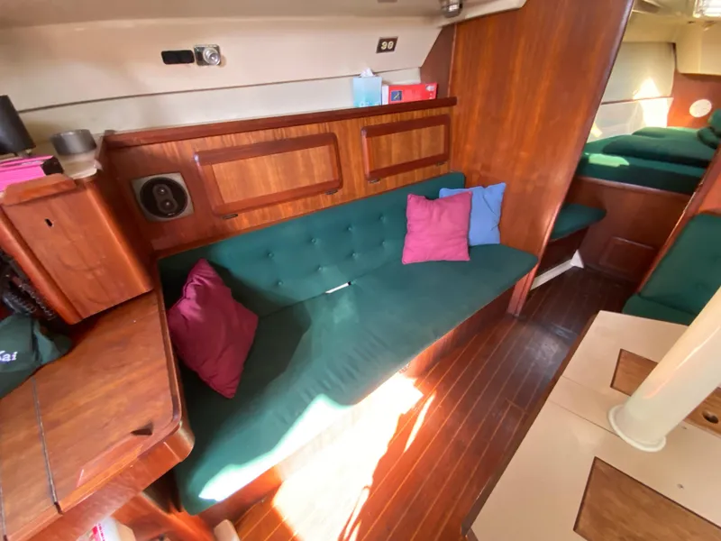 Slide: The Image of Interior of 1989 Hunter Legend 40 sailboat with green seating and colorful cushions. - 7