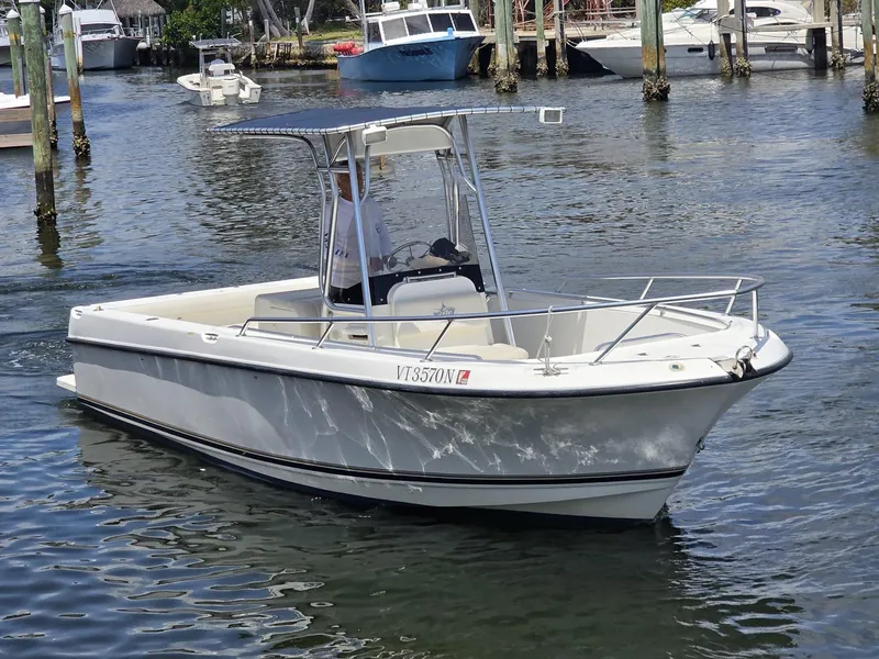 The Image of 1999 Shamrock 246 Open boat cruising in a marina, featuring a sleek white design. - 0