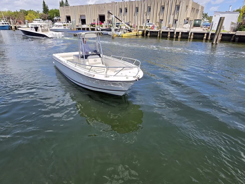 Slide: The Image of 1999 Shamrock 246 Open boat on water near a dock, sunny day. - 2