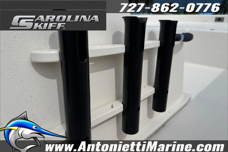Slide: The Image of 2025 Carolina Skiff E20 JVX boat detail with rod holders, logo, and contact information. - 11