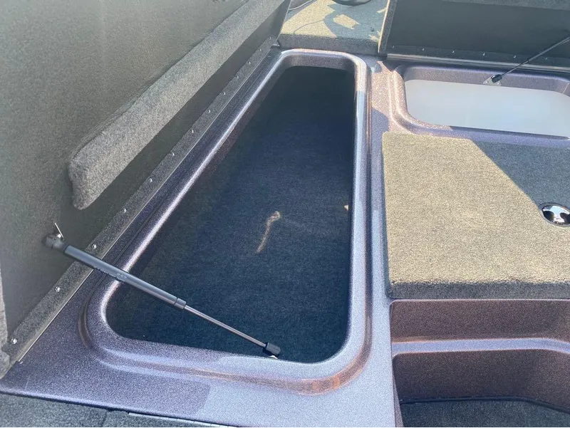 Slide: The Image of 2025 Skeeter ZX150 boat storage compartment with open lid and hydraulic support. - 8