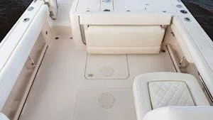 Slide: The Image of 2025 Grady-White Freedom 235 boat interior with cushioned seating and storage compartments. - 10