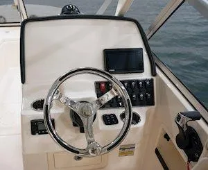 Slide: The Image of 2025 Grady-White Freedom 235 boat dashboard with steering wheel and control panel. - 12