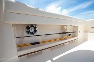 Slide: The Image of 2025 Grady-White Freedom 235 boat storage compartment with fishing rod and speaker. - 17