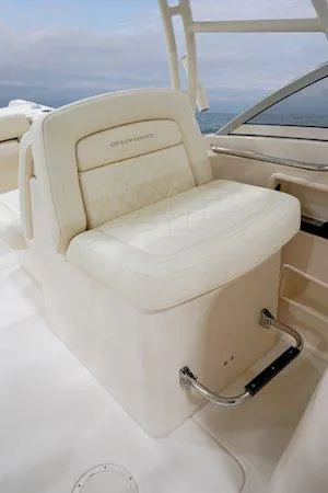 Slide: The Image of 2025 Grady-White Freedom 235 boat seat with white upholstery and chrome footrest. - 19