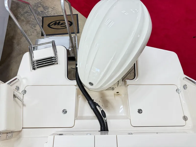 Slide: The Image of 2025 Grady-White Freedom 235 boat engine and deck view with ladder. - 3
