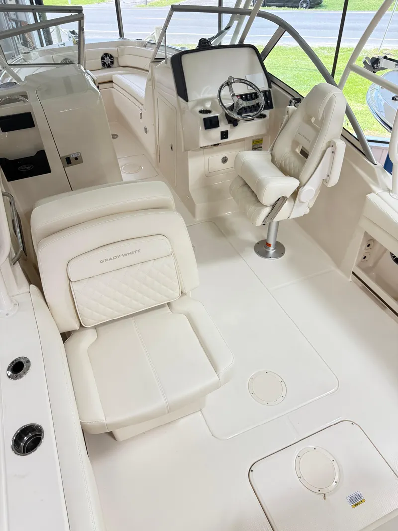 Slide: The Image of 2025 Grady-White Freedom 235 boat interior with white seating and steering console. - 9
