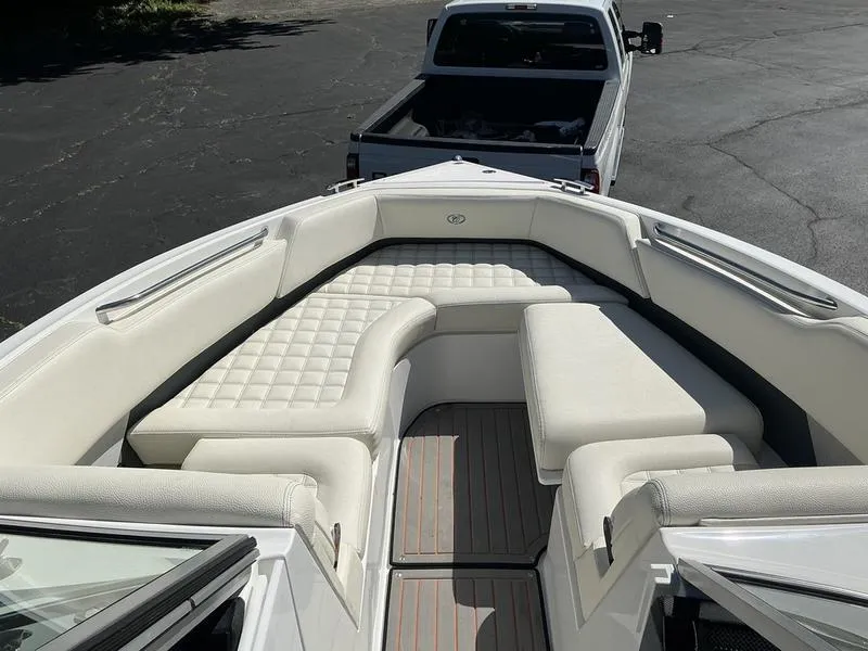 Slide: The Image of 2021 Cobalt R7 Surf boat interior with white cushioned seating, parked on a trailer. - 3
