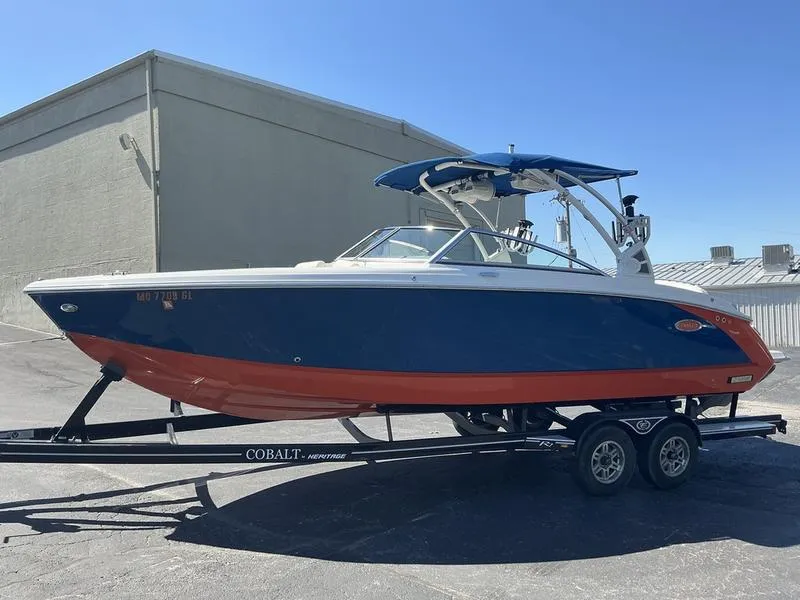 Slide: The Image of 2021 Cobalt R7 Surf boat on trailer, blue and red design, parked outdoors. - 6