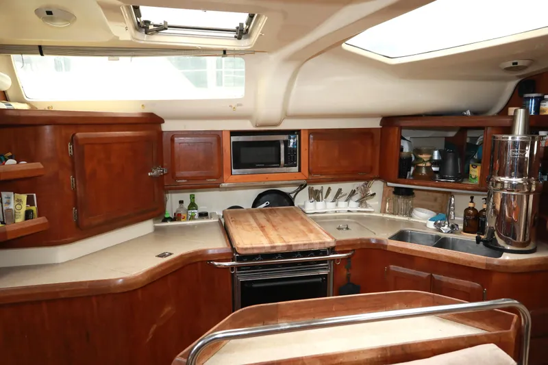 Slide: The Image of Interior of a 1995 Hunter 430 yacht kitchen with wooden cabinetry and modern appliances. - 21
