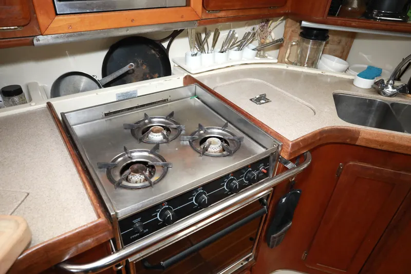 Slide: The Image of Compact kitchen in a 1995 Hunter 430 yacht with a three-burner stove and sink. - 22