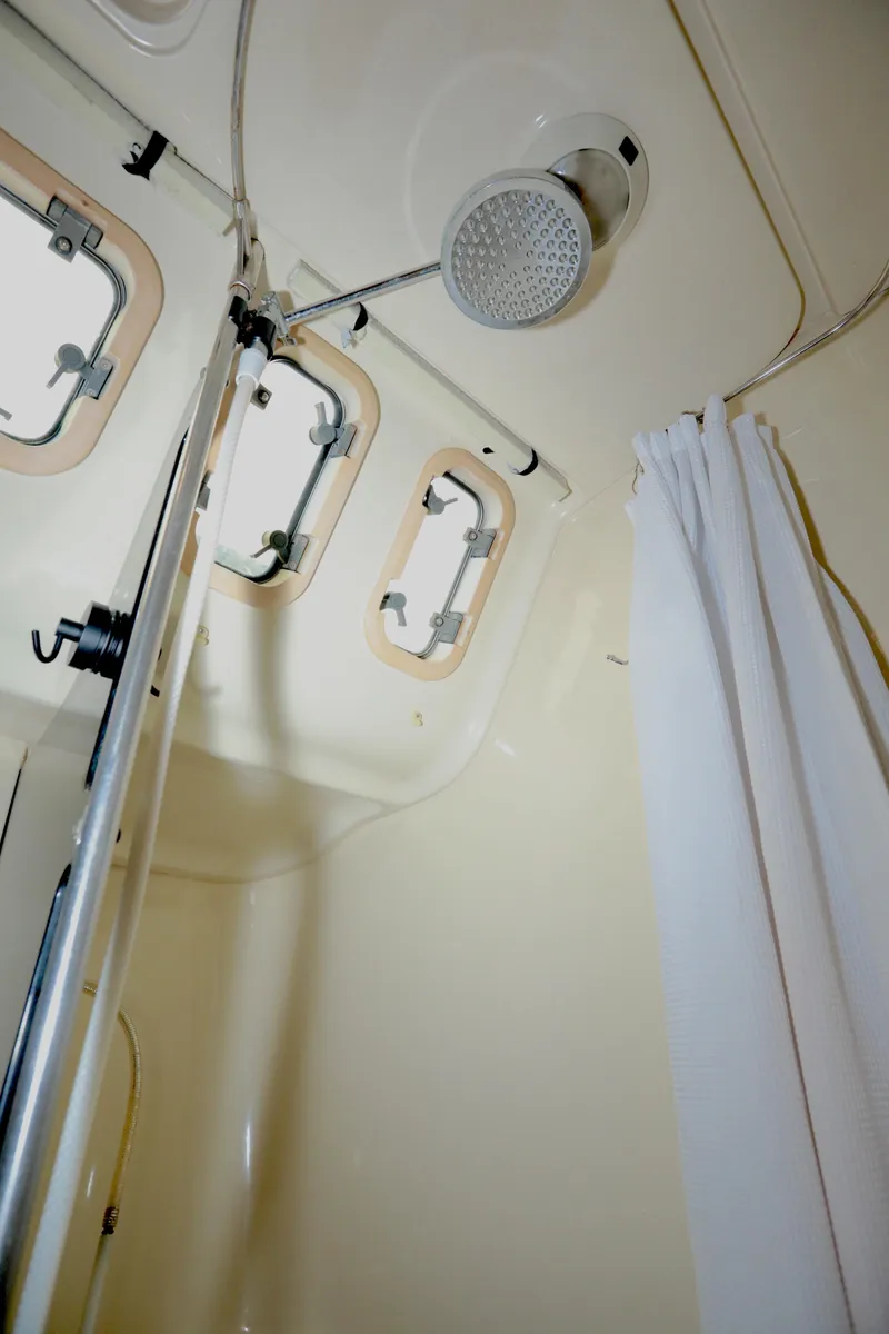 Slide: The Image of Interior of 1995 Hunter 430 sailboat shower with curtain and portholes. - 31