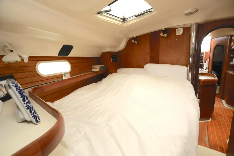 Slide: The Image of Cozy cabin interior of 1995 Hunter 430 sailboat with wooden accents and white bedding. - 33