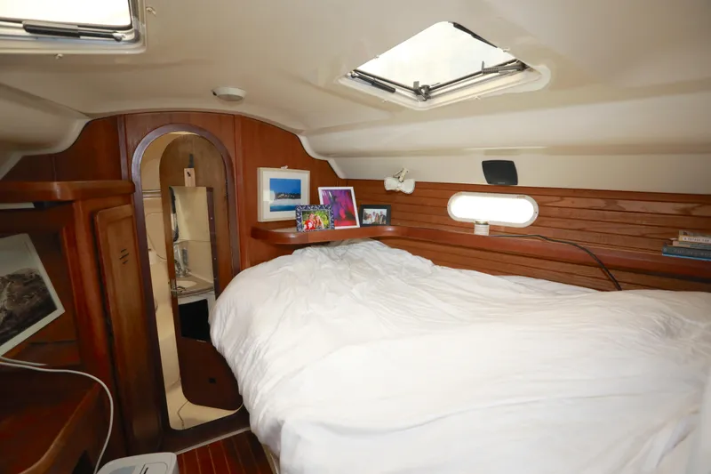 Slide: The Image of Cozy cabin interior of 1995 Hunter 430 sailboat with wooden accents and comfortable bedding. - 34
