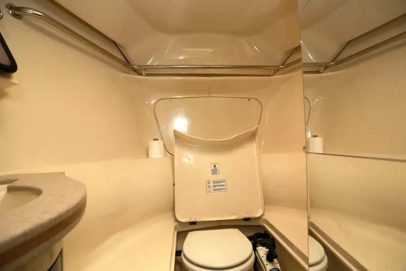 Slide: The Image of Bathroom interior of a 1995 Hunter 430 yacht, featuring a compact toilet and mirror. - 37