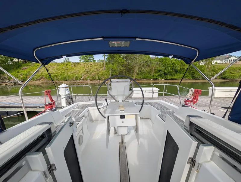 Slide: The Image of 2015 Beneteau Oceanis 37 Platinum sailboat cockpit with blue canopy and steering wheel. - 14