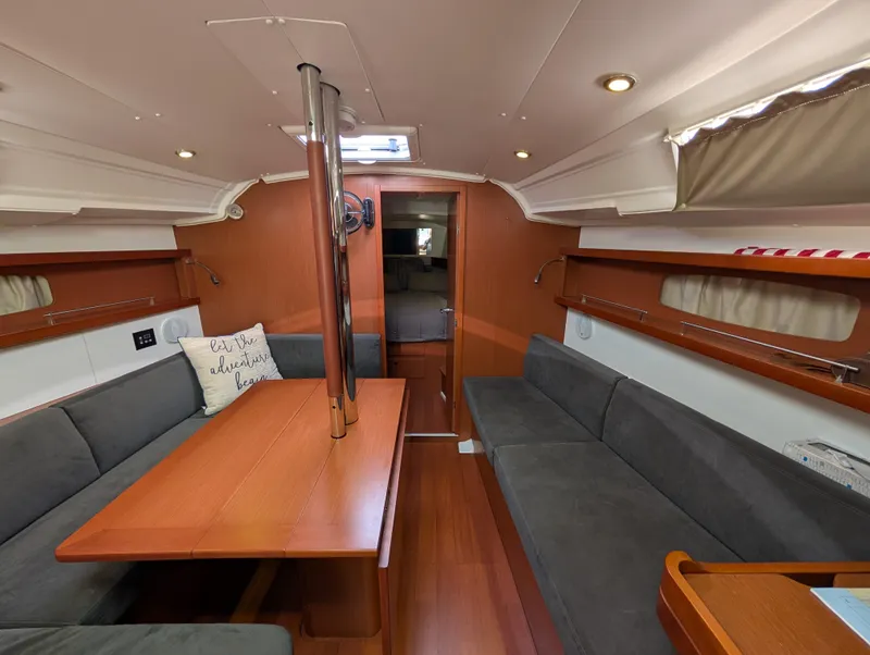 Slide: The Image of 2015 Beneteau Oceanis 37 Platinum interior with wood finish and gray seating. - 16