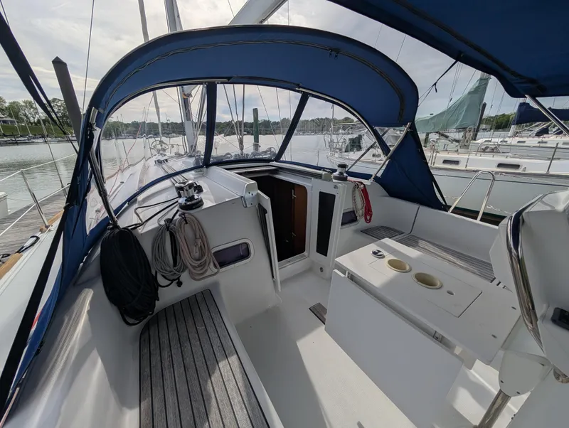 Slide: The Image of Cockpit of 2015 Beneteau Oceanis 37 Platinum sailboat with blue canopy and marina view. - 7
