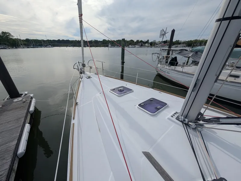 Slide: The Image of 2015 Beneteau Oceanis 37 Platinum sailboat docked at a marina, calm waters, overcast sky. - 9