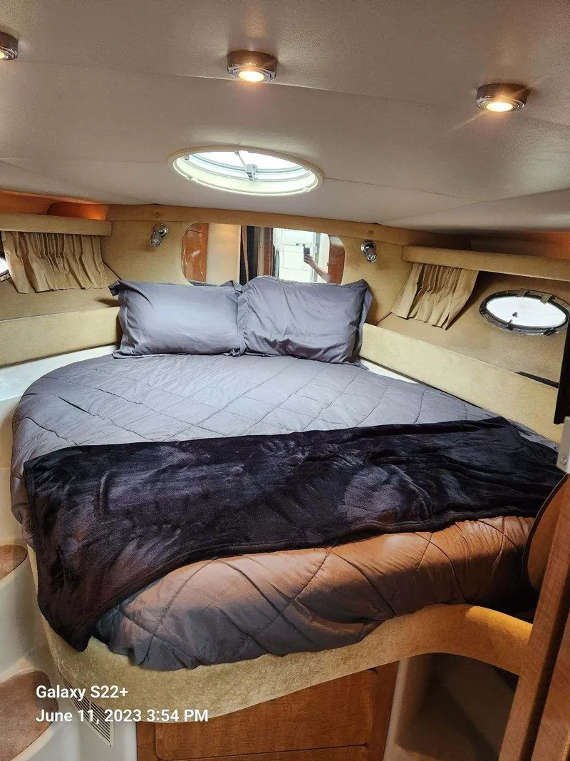Slide: The Image of Cozy bedroom interior of 2003 Regal 3860 Commodore yacht with circular bed and porthole windows. - 3