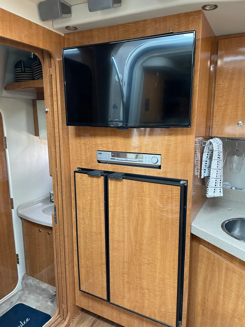 Slide: The Image of Interior of 2003 Regal 3860 Commodore yacht with TV, fridge, and sink. - 9
