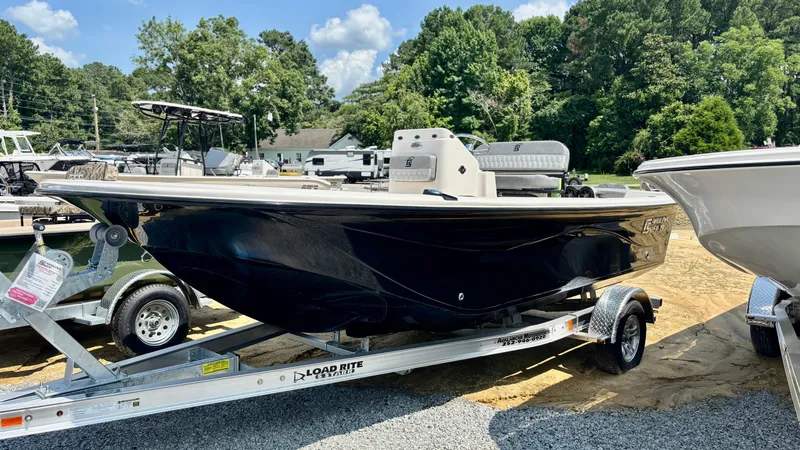 The Image of 2025 Carolina Skiff 19 LS Stealth Edition boat on trailer, outdoors, sunny day. - 1